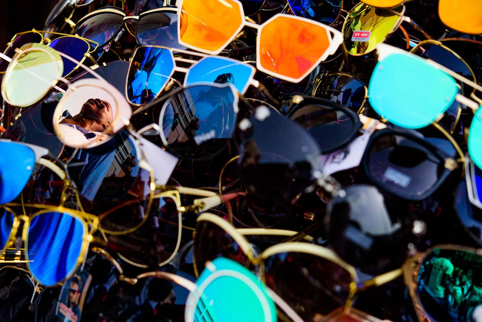 A vendor's table of sunglasses, stacked close.
